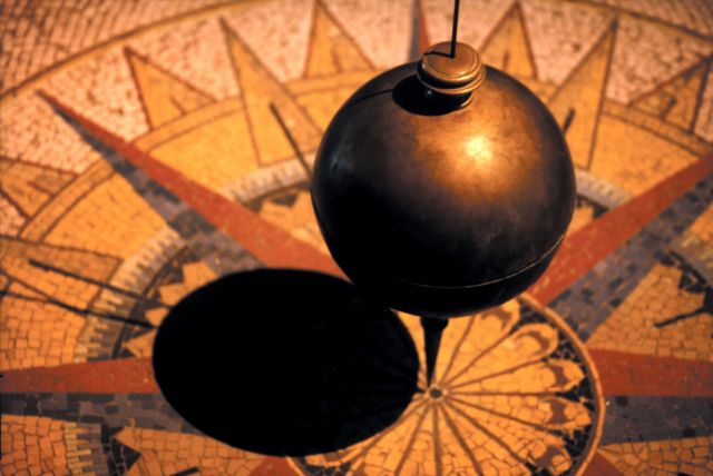 Foucault pendulum demonstrates Earth's rotation at science museum. Mosaic floor adds antique look. Ideal for educational materials, science infographics, museum brochures, physics demonstration visuals.