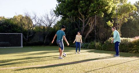 Family Enjoying Playful Afternoon Soccer Match in Backyard