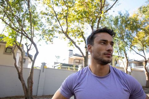 Man Relaxing Outdoors in Suburban Setting for Fitness Inspiration