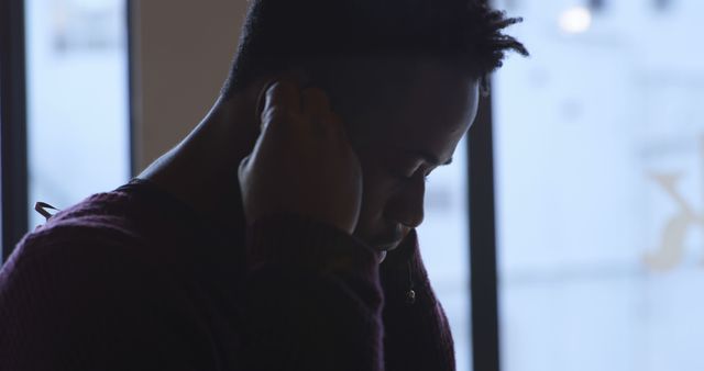 Young Man Enjoying Music with Earphones Near Window - Download Free Stock Images Pikwizard.com