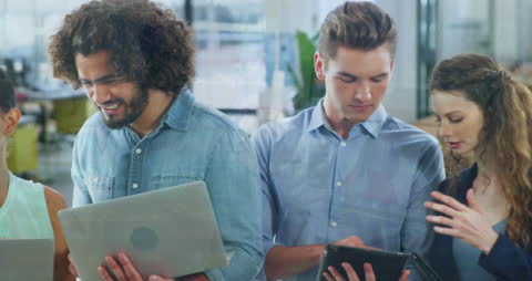 Diverse Team Analyzing Financial Data with Laptops and Tablets