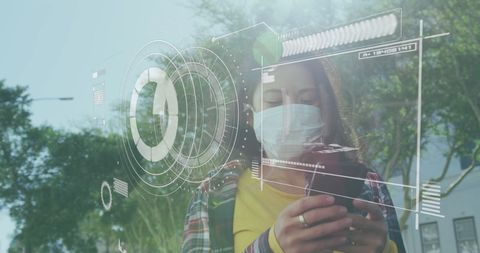 Masked woman using futuristic technology outdoors