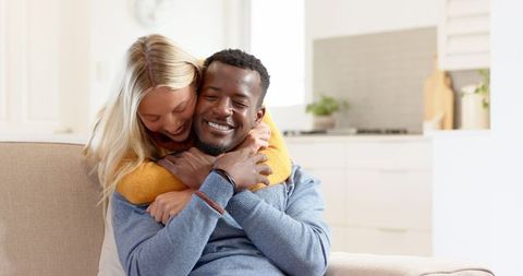 Happy Romantic Couple Embracing on Cozy Living Room Sofa