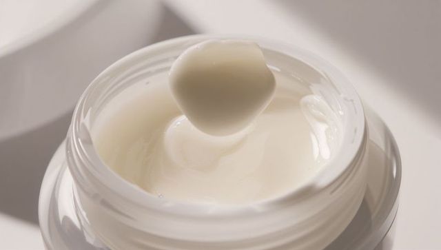 Skincare cream jar with suspended dollop, glossy moisturizer close-up for branding