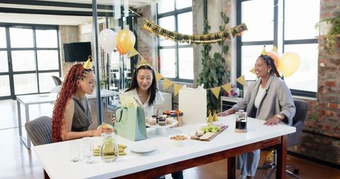 Colleagues celebrating birthday in office with decoration and gifts