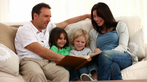 Happy Family Reading Together on Cozy Sofa at Home