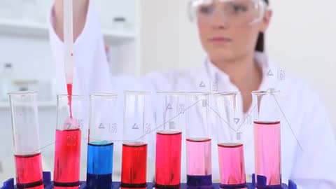 Technician Adding Colored Reagents to Test Tubes for Analysis