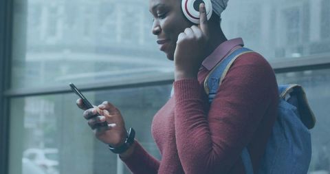 Young Woman Listening to Music with Headphones in Urban Environment