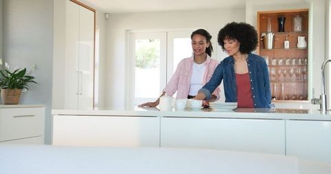 Diverse Women Sharing Joyful Moment in Bright Kitchen