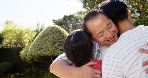 Asian Family Bonding in Sunlit Backyard Garden