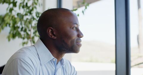 Smiling Man Looking Out Window Enjoying Moment of Reflection