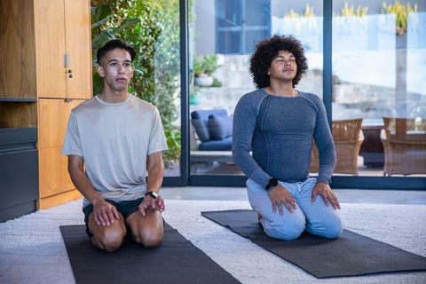 Diverse men practicing indoor yoga for relaxation and wellness at home