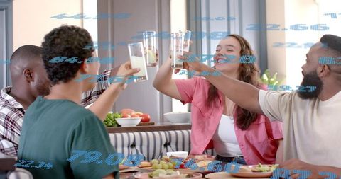 Friends clinking glasses and toasting over brunch at home dining table, celebrating joy