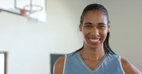 Basketball Athlete Smiling by Hoop in Minimalist Gym Setting