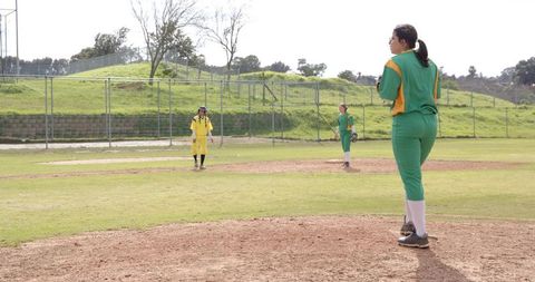 Female Softball Players Competing on Open Field in Spring