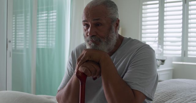 Senior Man with Cane Sitting by Bed in Sunlit Room - Download Free Stock Images Pikwizard.com