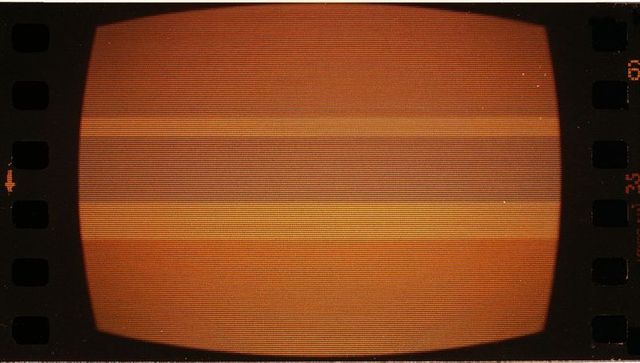 Orange glow vintage crt monitor inside editing room with film strip