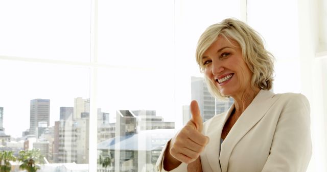 Happy businesswoman giving thumbs up in the office