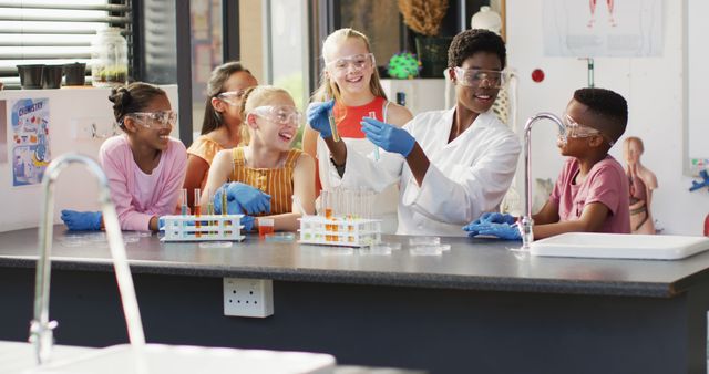 Group of children from diverse backgrounds participating in science experiment in classroom. Teacher wearing lab coat and safety goggles guiding them. Ideal for illustrating educational activities, science learning, teamwork, diversity, and interactive teaching methods.