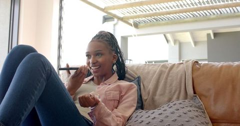 Young Woman Chatting on Smartphone Lounging Comfortably