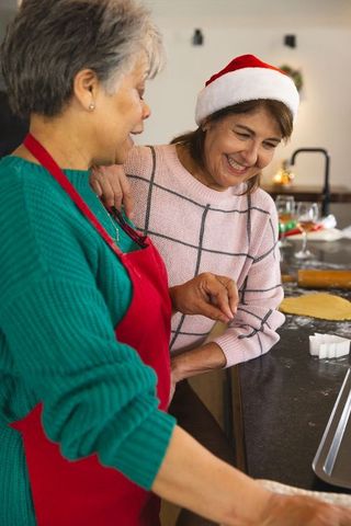 Mother and Daughter Bonding over Holiday Cookie Baking in Festive Kitchen