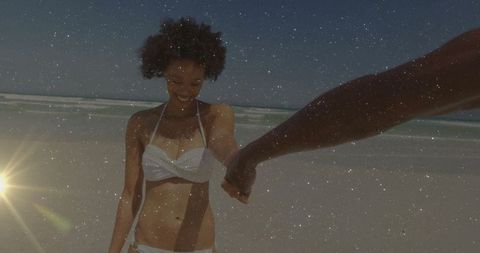 Woman in White Bikini Enjoying Beach Walk with Partner's Hand