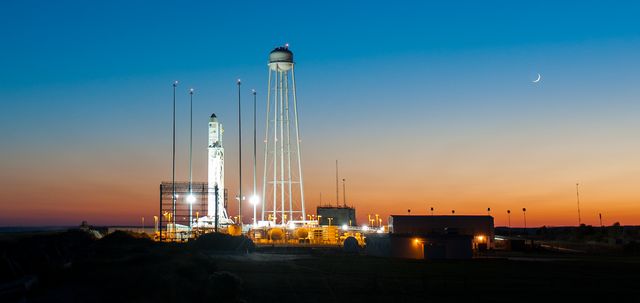 Stunning view of the Antares rocket with Cygnus spacecraft on the launch pad at Wallops Flight Facility during sunset. This moment captures the preparation for a significant cargo delivery mission to the International Space Station. Great resource for articles on space exploration, NASA missions, rocket launches, and technological advancements in space travel.