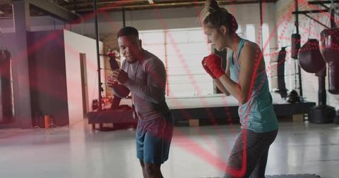 Personal Trainer Coaching Female Boxer in Industrial Loft Gym Practicing Footwork and Punch Techniqu
