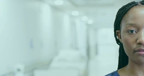 Professional Nurse Wearing Scrubs in Modern Hospital Corridor