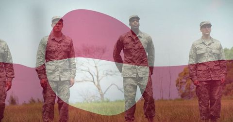 Uniformed soldiers standing in field with abstract red overlay for military concept