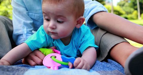 Mother Engaging with Baby Son on Picnic Blanket Outdoors