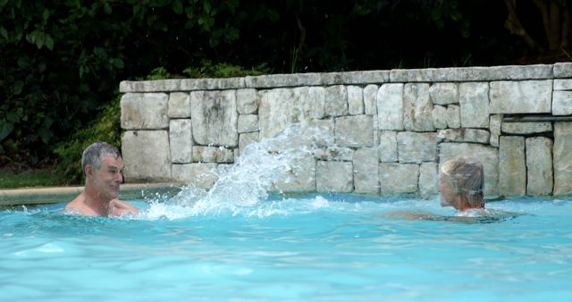 Senior Couple Splashing in Pool Enjoying Leisure Time - Download Free Stock Images Pikwizard.com