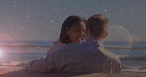 Romantic Multiracial Couple Embracing at Beach with Lens Flare Effect