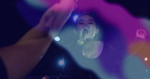 Chinese Singer Performing on Stage with Purple Spotlight