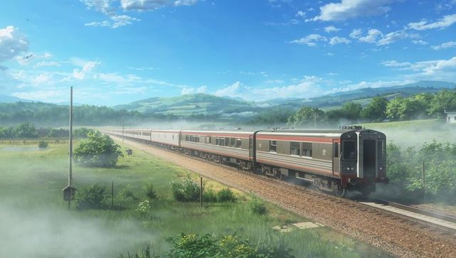 Silver-red passenger train traversing misty rural valley under blue sky