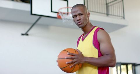 Focused Basketball Player Holding Ball Preparing for Game