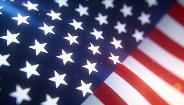 Waving american flag closeup showing stars and stripes fabric texture with bokeh light