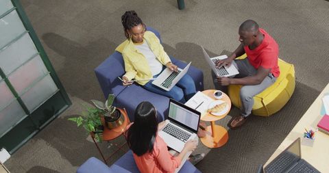 Diverse Team Collaborating on Project with Laptops in Modern Office