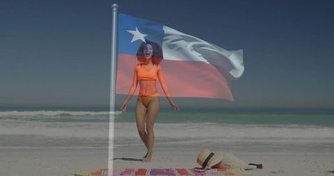 Walking along sunlit beach with chilean flag overlay, woman in orange bikini enjoying breeze