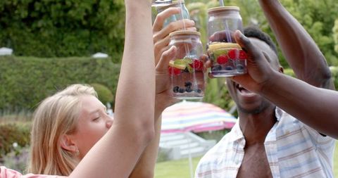 Diverse Friends Toasting Drinks in Garden Celebration