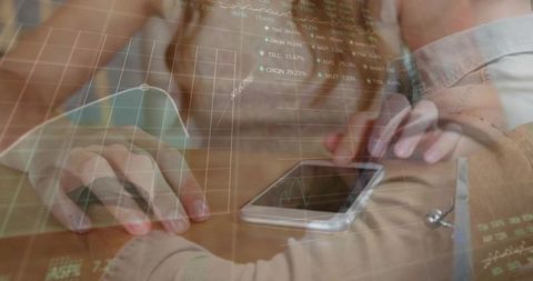 Hands Using Smartphone on Meeting Table with Finance Charts Overlay for Business Analytics