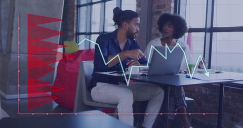 Diverse Business Team Analyzing Graphs on Laptop