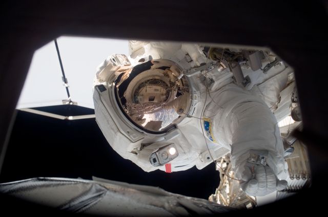 Astronaut engaged in a spacewalk outside the International Space Station. Suitable for content related to space exploration, NASA missions, space technology, and outer space research.