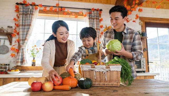 Family harvest arranging fresh vegetables into wicker basket in farmhouse kitchen