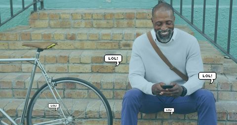 African American Man Laughing with Smartphone and Bicycle