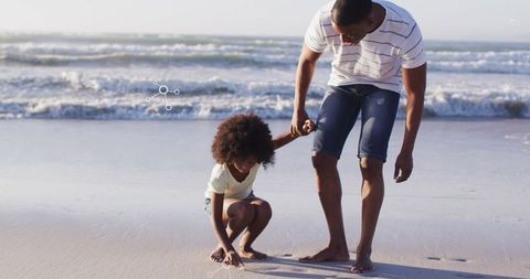 Father and son enjoying beach time collecting shells