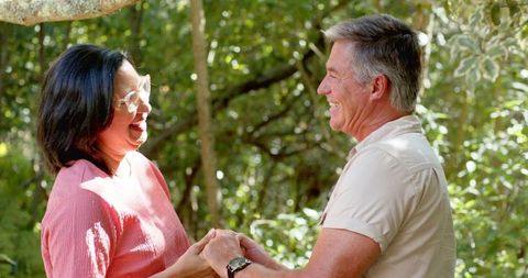 Joyful Couple Enjoying Nature in Sunlit Forest Clearing