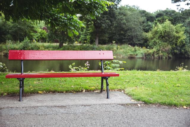Empty red wooden bench at lakeside, backgrounds
