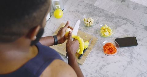 Preparing fresh fruit and vegetables in modern kitchen