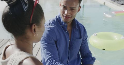 Couple Sitting by Pool Enjoying Conversation